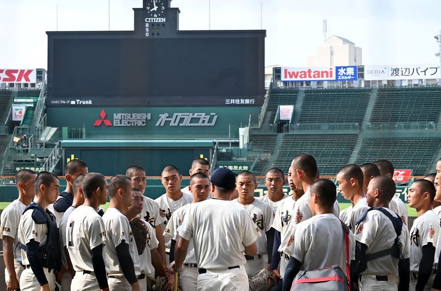 甲子園練習前に一塁ベンチ前で円陣を組む神村学園ナイン｜4年連続出場